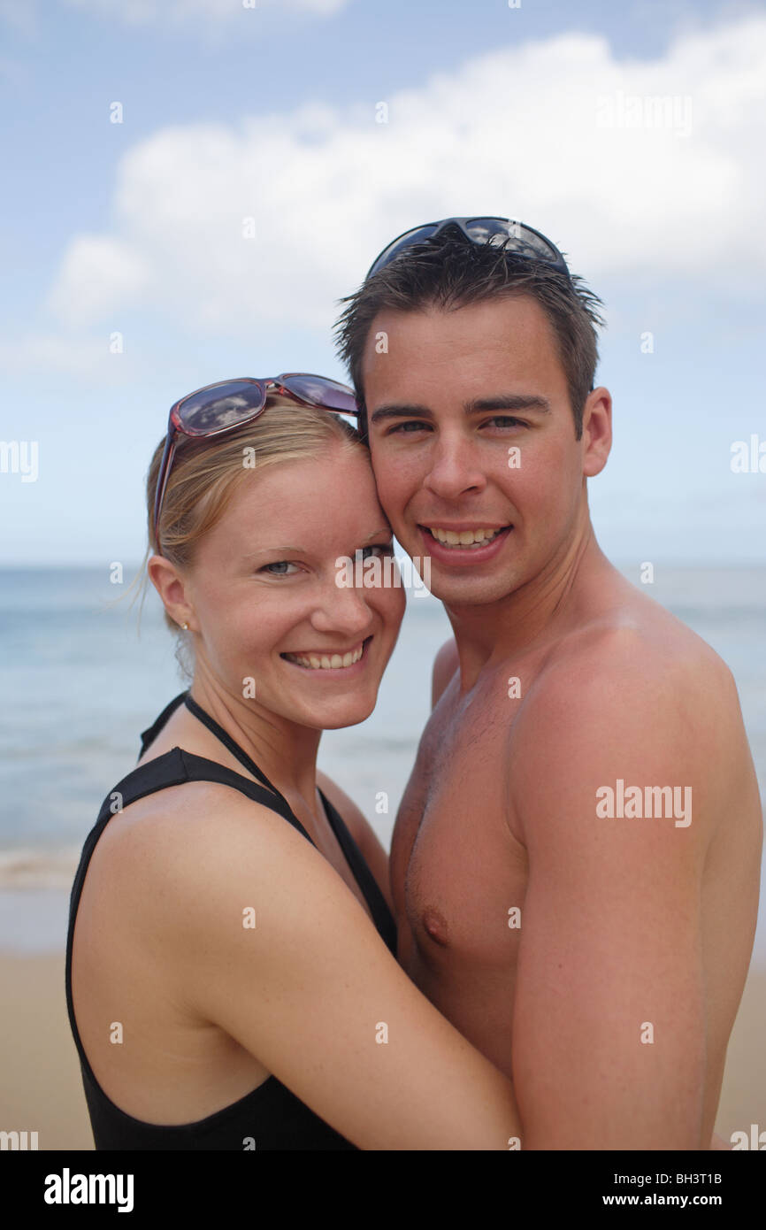 Junges Paar am Strand, umarmen lächelnd Stockfoto