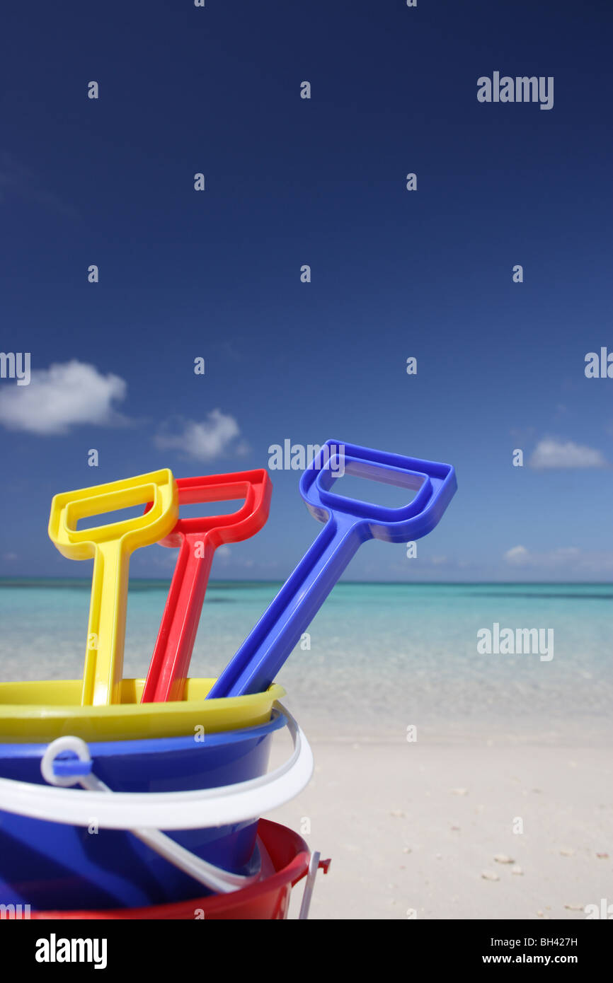 Drei Kinder Spielzeug Eimer und Spaten auf einem einsamen tropischen Strand Stockfoto