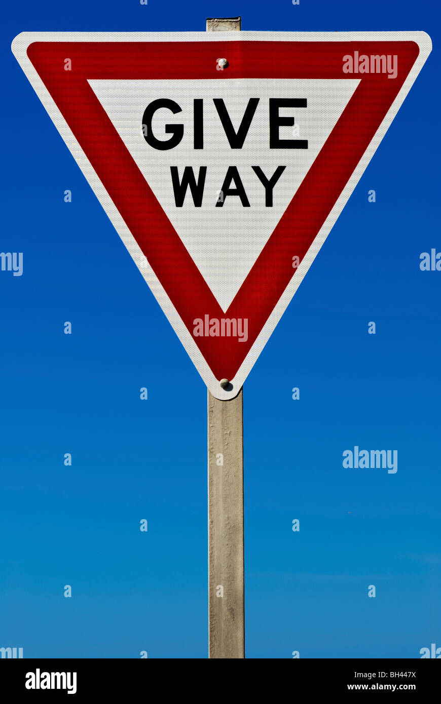 Ein geben Weg Verkehrsschild isoliert auf einem blauen Gradienten Himmel. Stockfoto