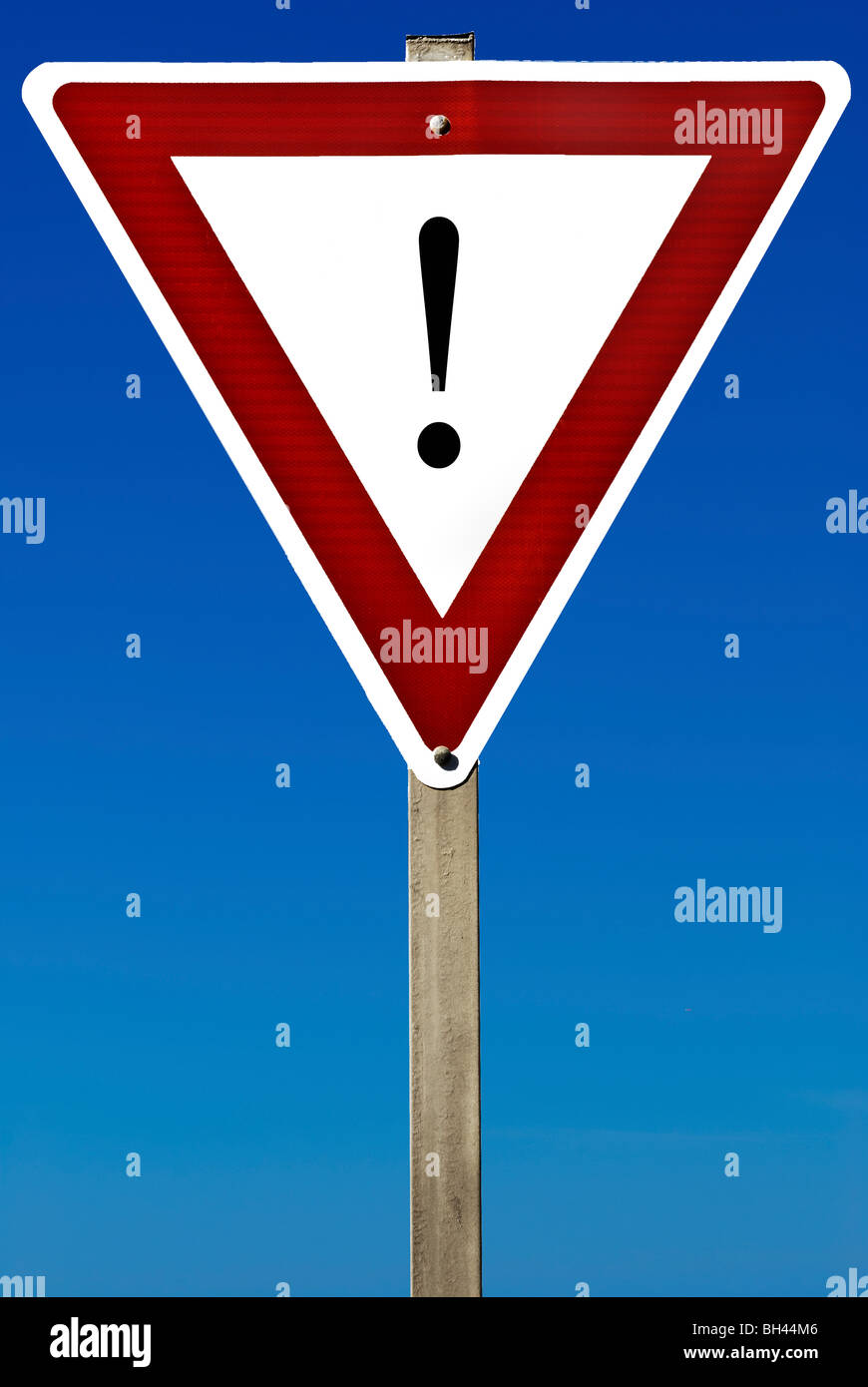 Ein Schild mit einem Ausrufezeichen drauf isoliert auf einem blauen Himmel. Stockfoto