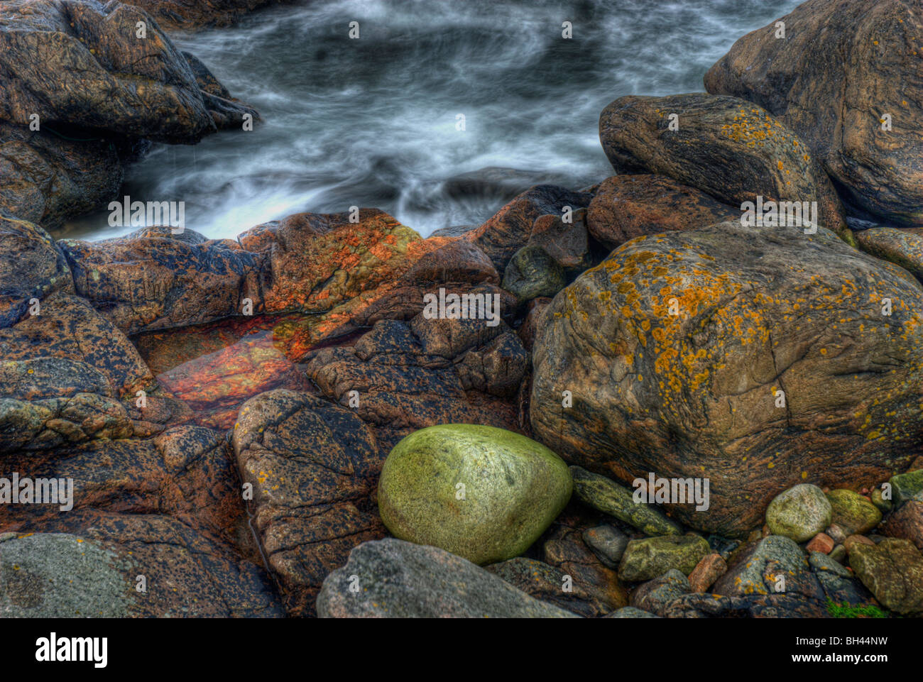 Bunte Felsen, Kies und Meerwasser am Ufer in der Nähe von Hafen von Aberdeen. Stockfoto