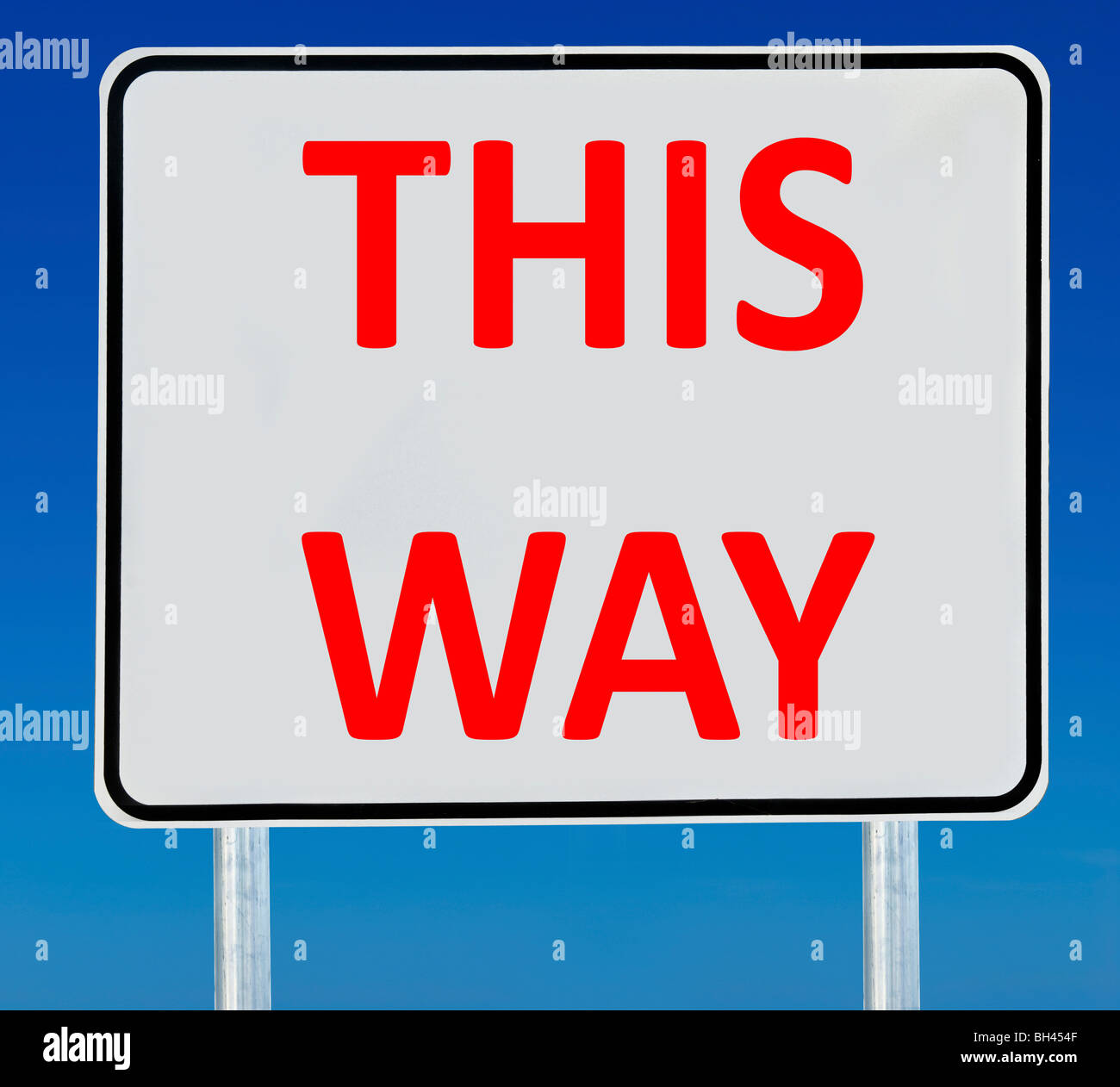 Ein "This Way"-Schild, isoliert auf einem abgestuften blauen Himmel. Stockfoto