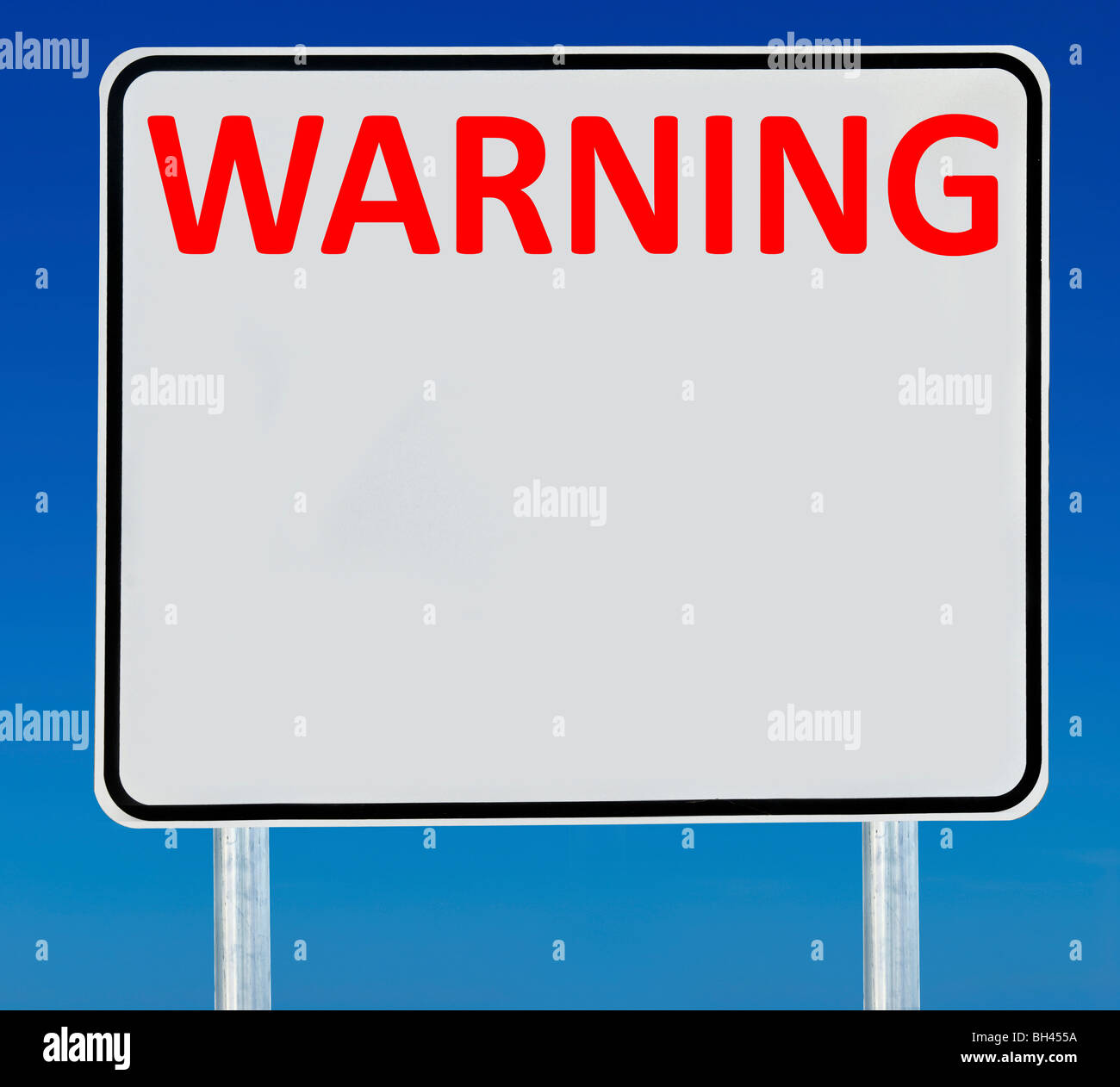 Ein 'Warnung' Zeichen isoliert auf einem abgestuften blauen Himmel. Stockfoto