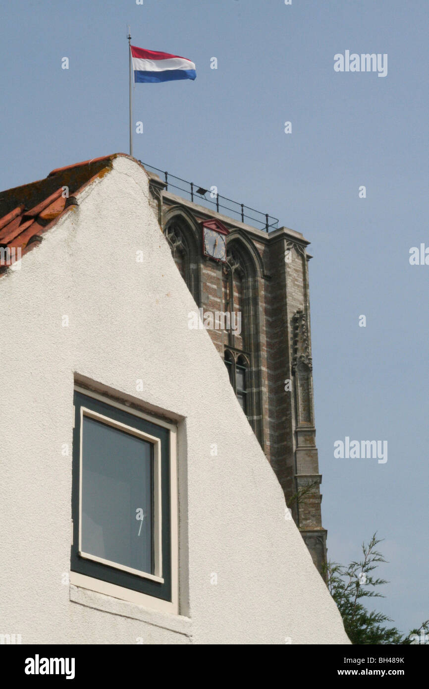 Die niederländische Flagge auf der Oberseite der Kirche Turm Goedereede scheint auch auf der Spitze eines Hauses zu sein. Stockfoto