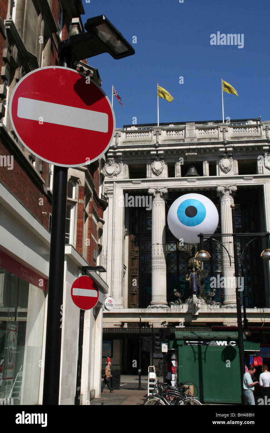 Straßenszene in der Oxford Street zeigt ein große Anziehung Auge auf der Fassade von Selfridges. Stockfoto