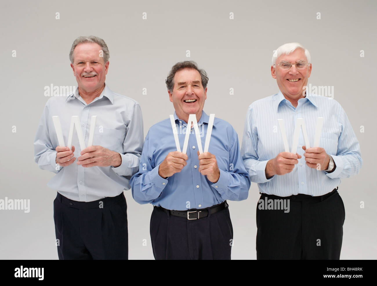 Drei senior-Unternehmer jede holding die Buchstaben "W", Lächeln Stockfoto