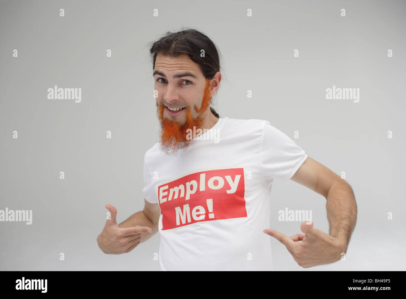 Ein junger Mann auf seinem T-shirt mit der Meldung "Beschäftigen mich!" gedruckt, Lächeln Stockfoto