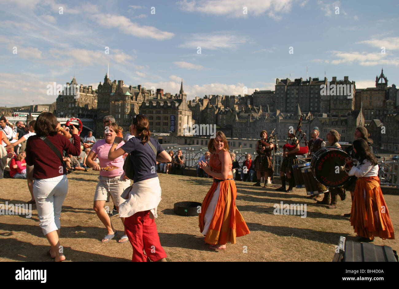 Menschen tanzen zur Musik der Dudelsackpfeifer aus Clan Wallace Society vor Edinburgh Castle in Edinburgh, Schottland. Stockfoto