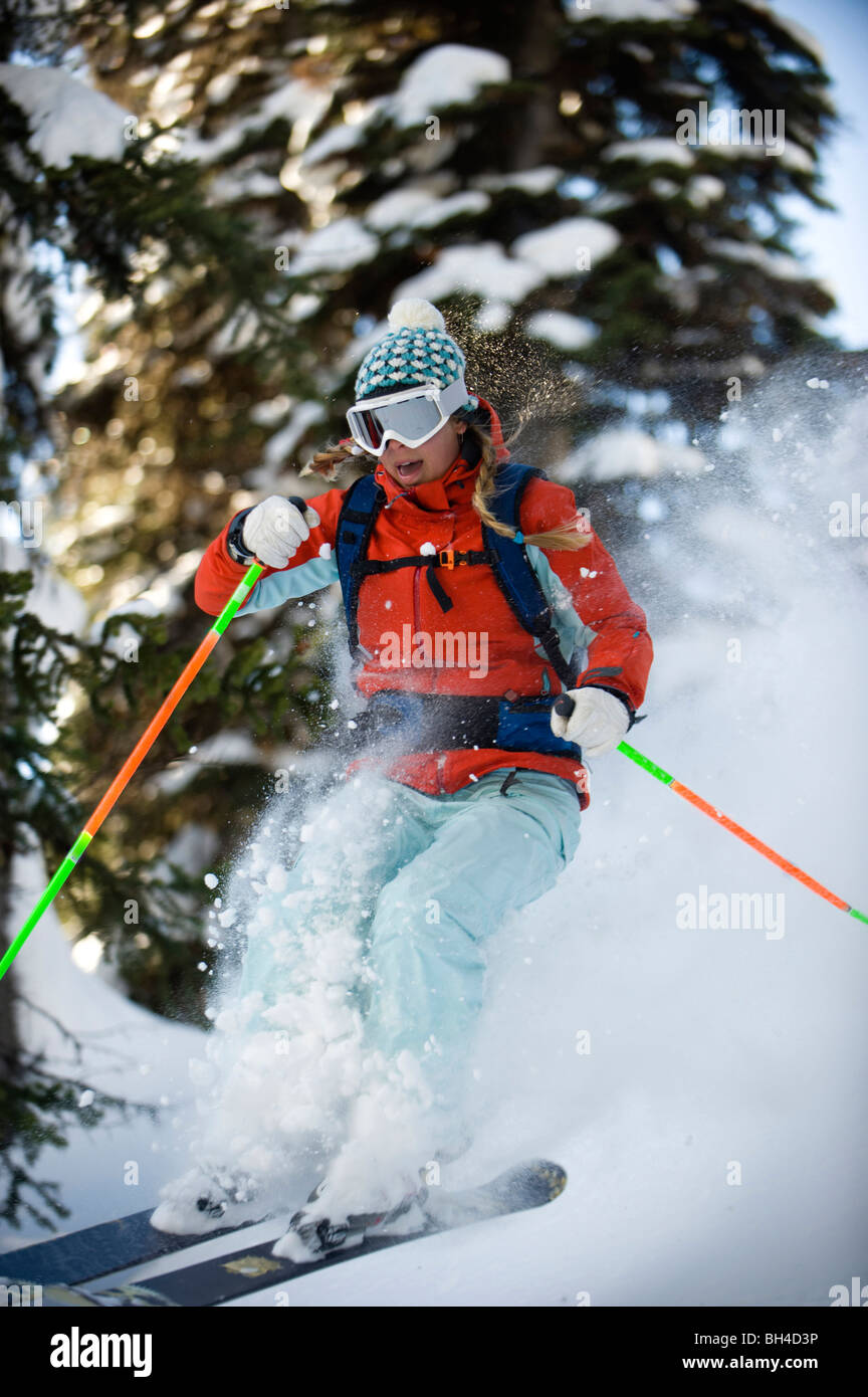 Ein Frau Backcountry Skifahrer fängt Luft in den Bäumen der Selkirk Mountains, Kanada. Stockfoto