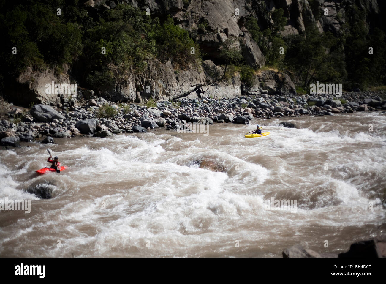Zwei Kajakfahrer paddeln Sie durch Wildwasser auf einem Fluss. Stockfoto