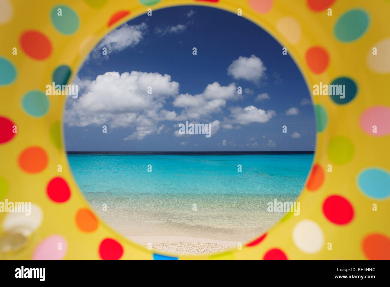 Einem tropischen Strand, betrachtet durch das Loch in einem bunten aufblasbaren Gummiring (Querformat) Stockfoto