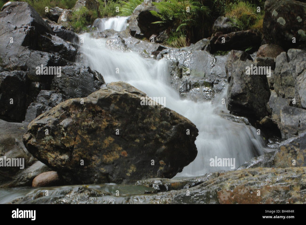 Kleiner Wasserfall in den Fluss Nevis mit einem großen Granitblock taumeln. Stockfoto