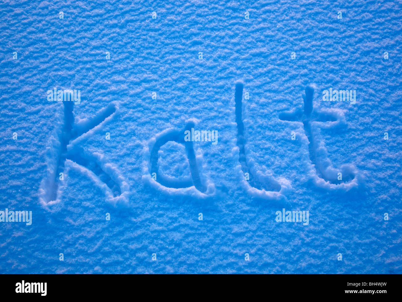 Das deutsche Wort für Kälte - Kalt - in den Schnee geschrieben. Stockfoto