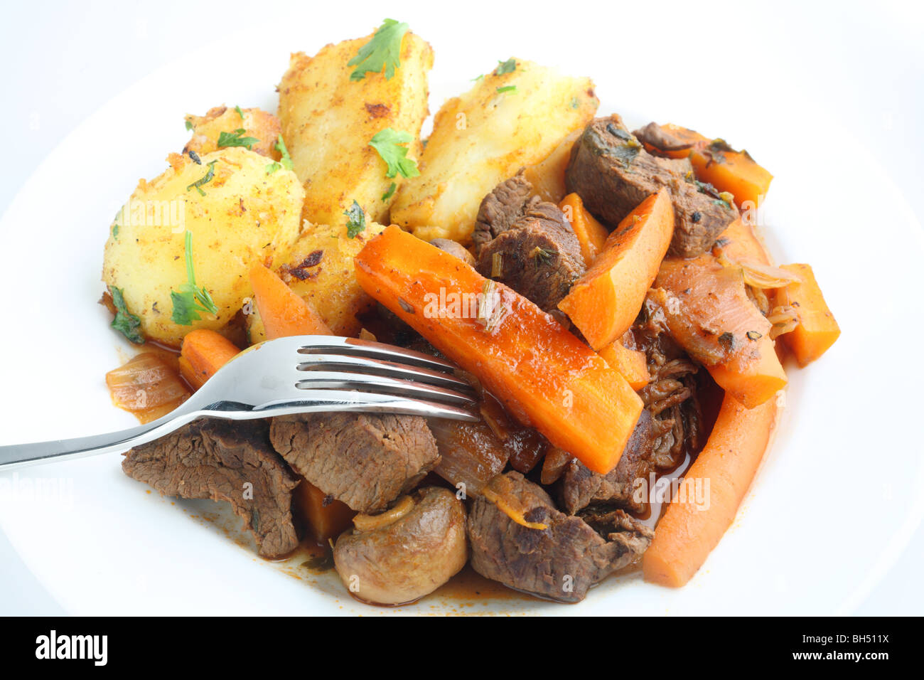 Französisches Rindfleisch und Karotten-Eintopf mit Kräutern, serviert mit Bratkartoffeln mit Petersilie garniert Stockfoto