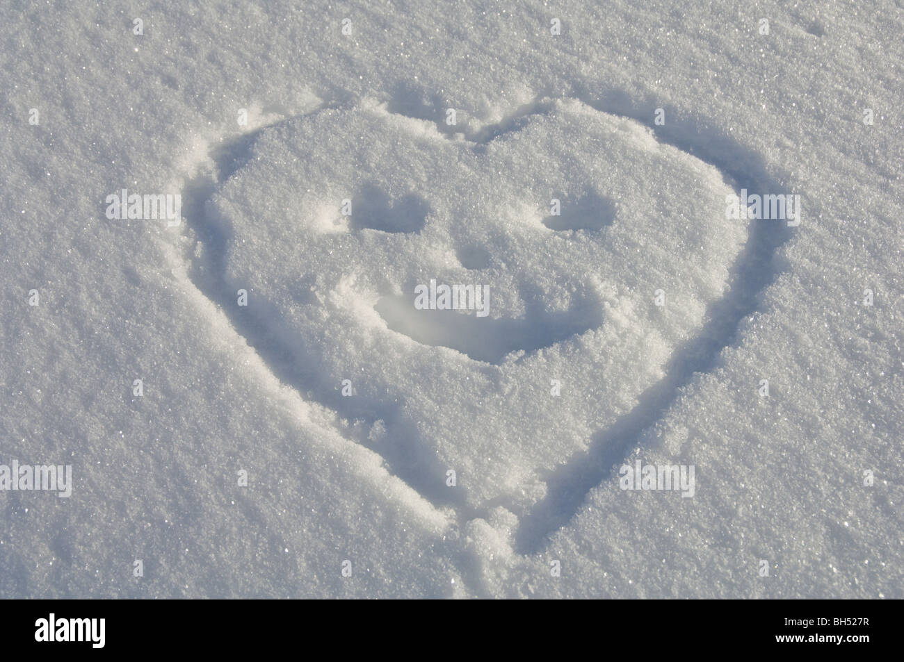 Herzförmige Smiley im Schnee gezeichnet. Stockfoto