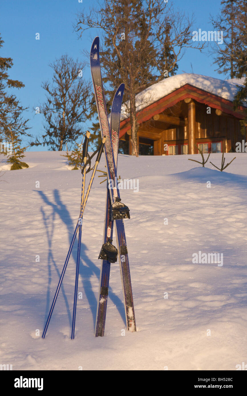 Ferienchalet mit Schnee und ein paar Ski. Stockfoto