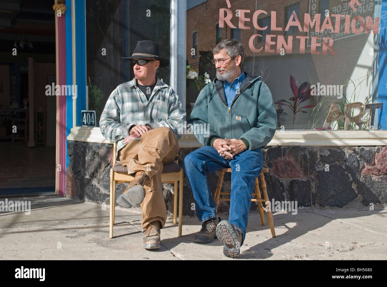 Zwei Männer in Carrizozo genießen Sie die Sonne und beobachten Passanten an einem warmen Tag im Januar. Stockfoto