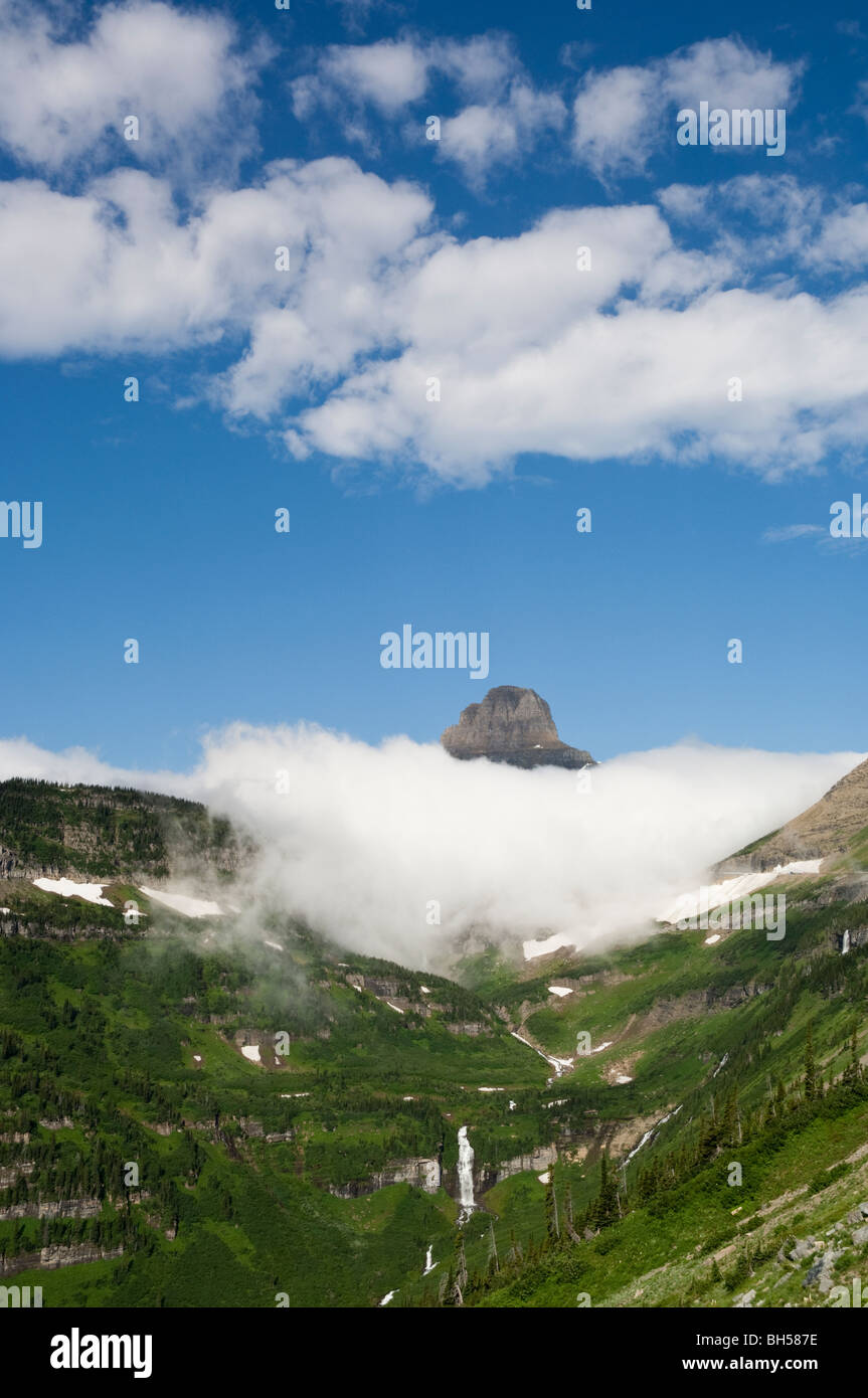 Mt. Reynolds auf Logan Pass ragt über eine Schicht von dicken Wolken und Reynolds Creek Kaskaden unterhalb Stockfoto