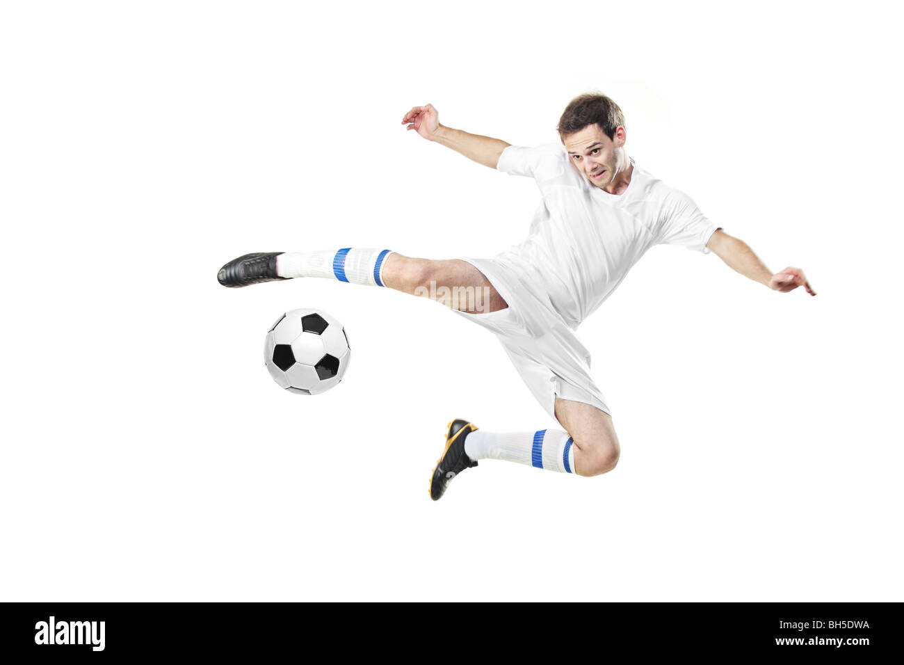 Fußball-Spieler einen Ball isoliert auf weißem Hintergrund Stockfoto