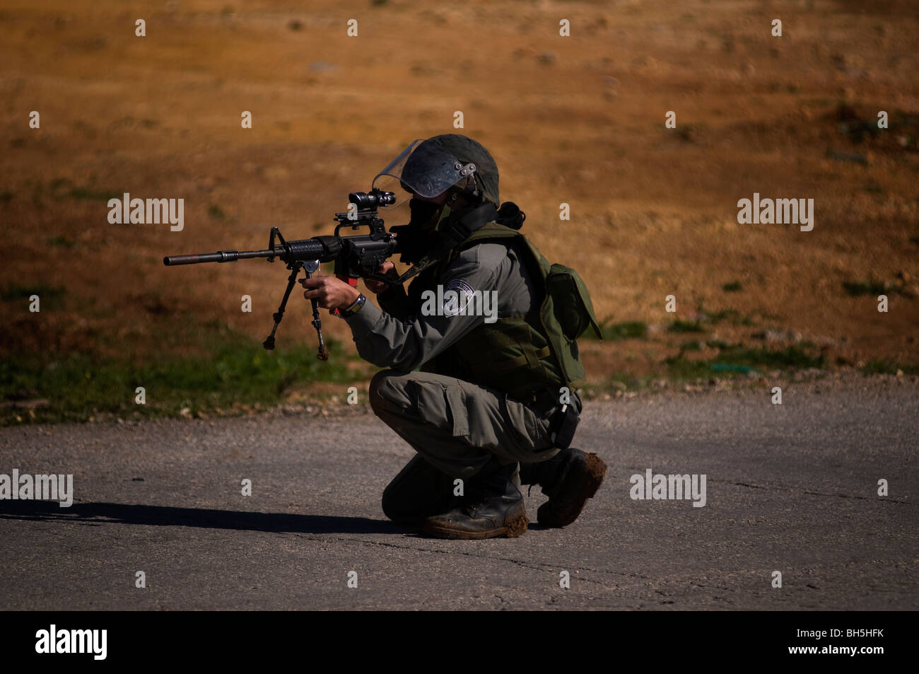 Eine israelische Grenze Polizist feuert Gummigeschosse gegen palästinensische Demonstranten während eines heftigen Protest in der West Bank Israel Stockfoto