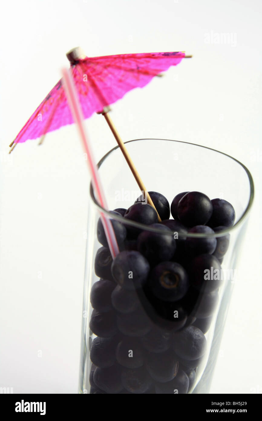 Blaubeeren, Stroh und cocktail Regenschirm in ein Trinkglas Stockfoto