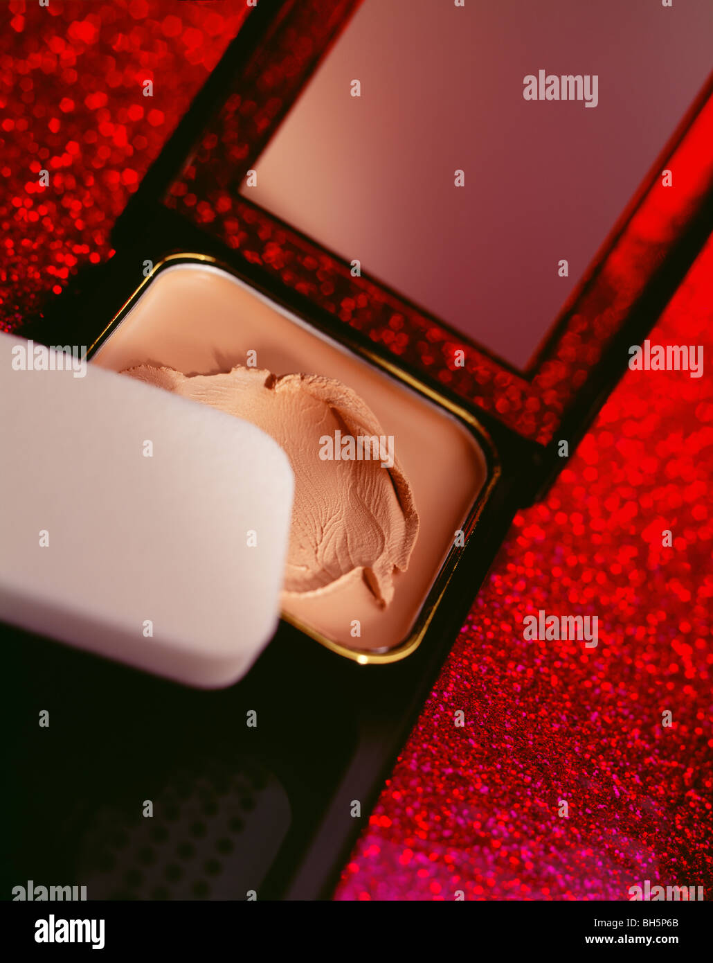 Foundation Make-up mit Baumwolle Applikator auf rote Fläche sehr bunt Stockfoto