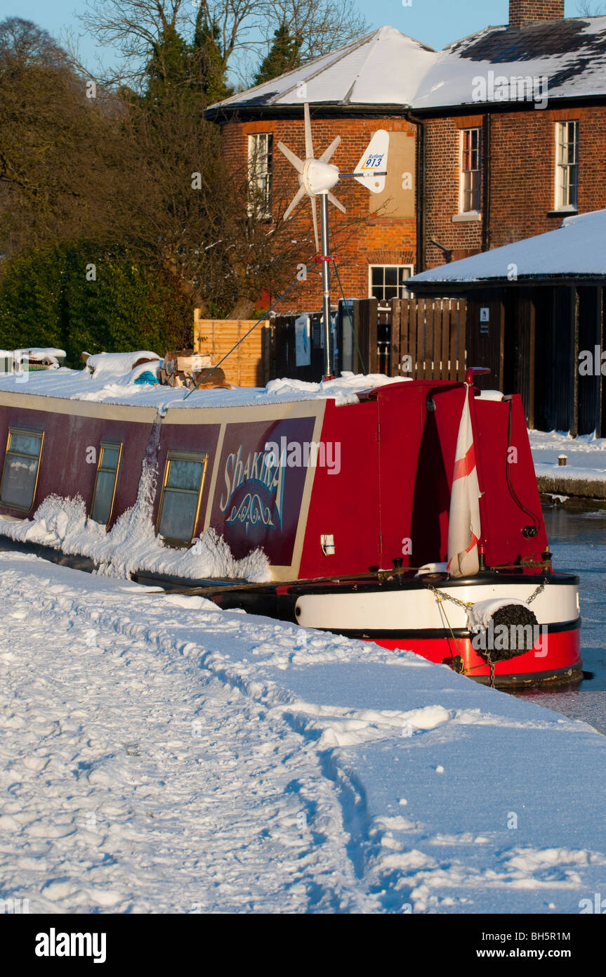 Schmale Boot mit Windgenerator vor Anker auf dem gefrorenen Llangollen Kanal bei Ellesmere, Shropshire Stockfoto