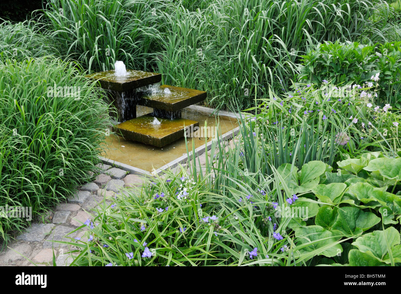 Mehrjährig Garten mit Springbrunnen Stockfoto