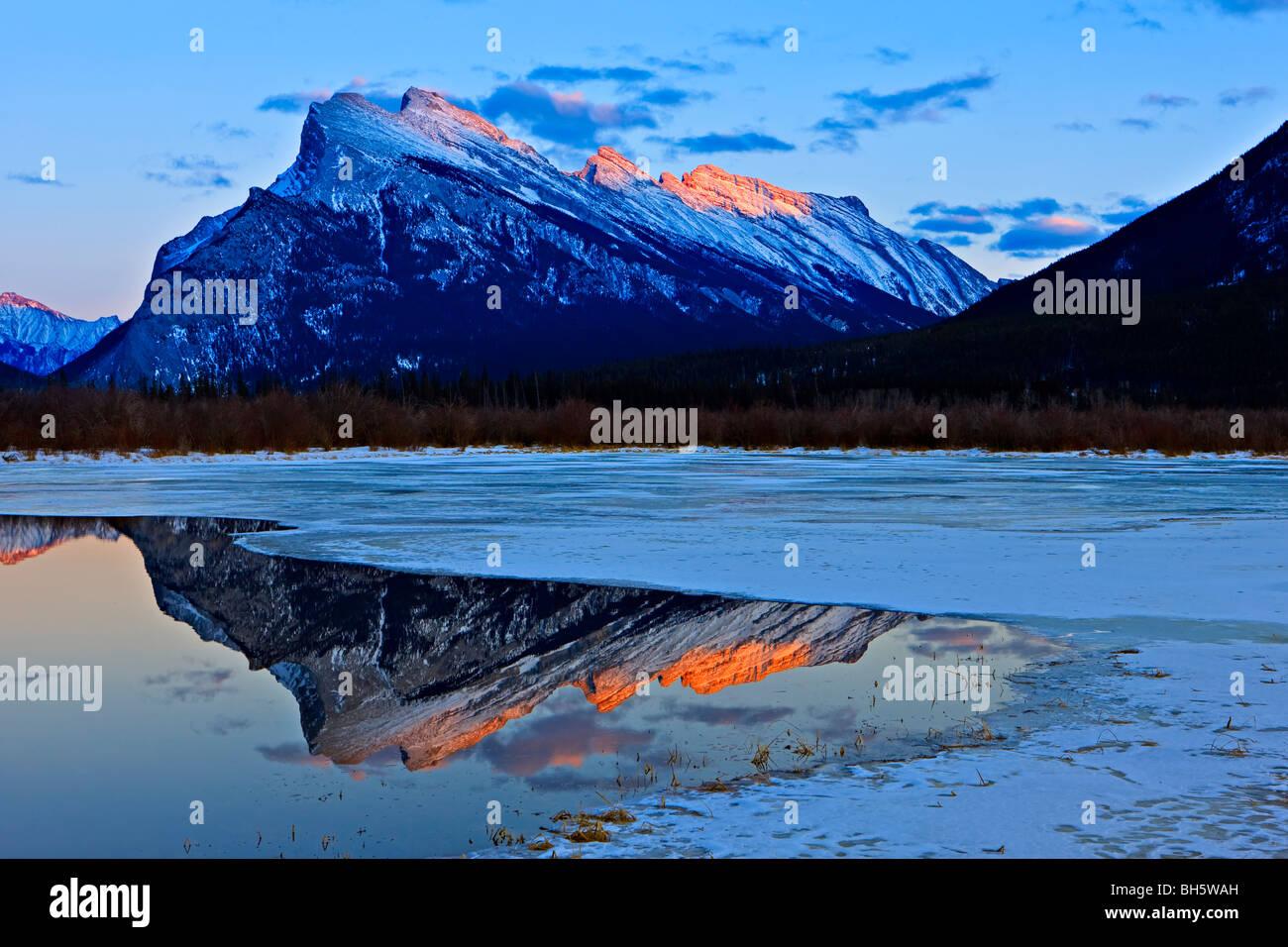 Zeigen Sie mit Reflexionen (von links nach rechts) die Fairholme Mountain Range (2995 m/9825 Füße), Tunnel Mountain (1692 m an Stockfoto