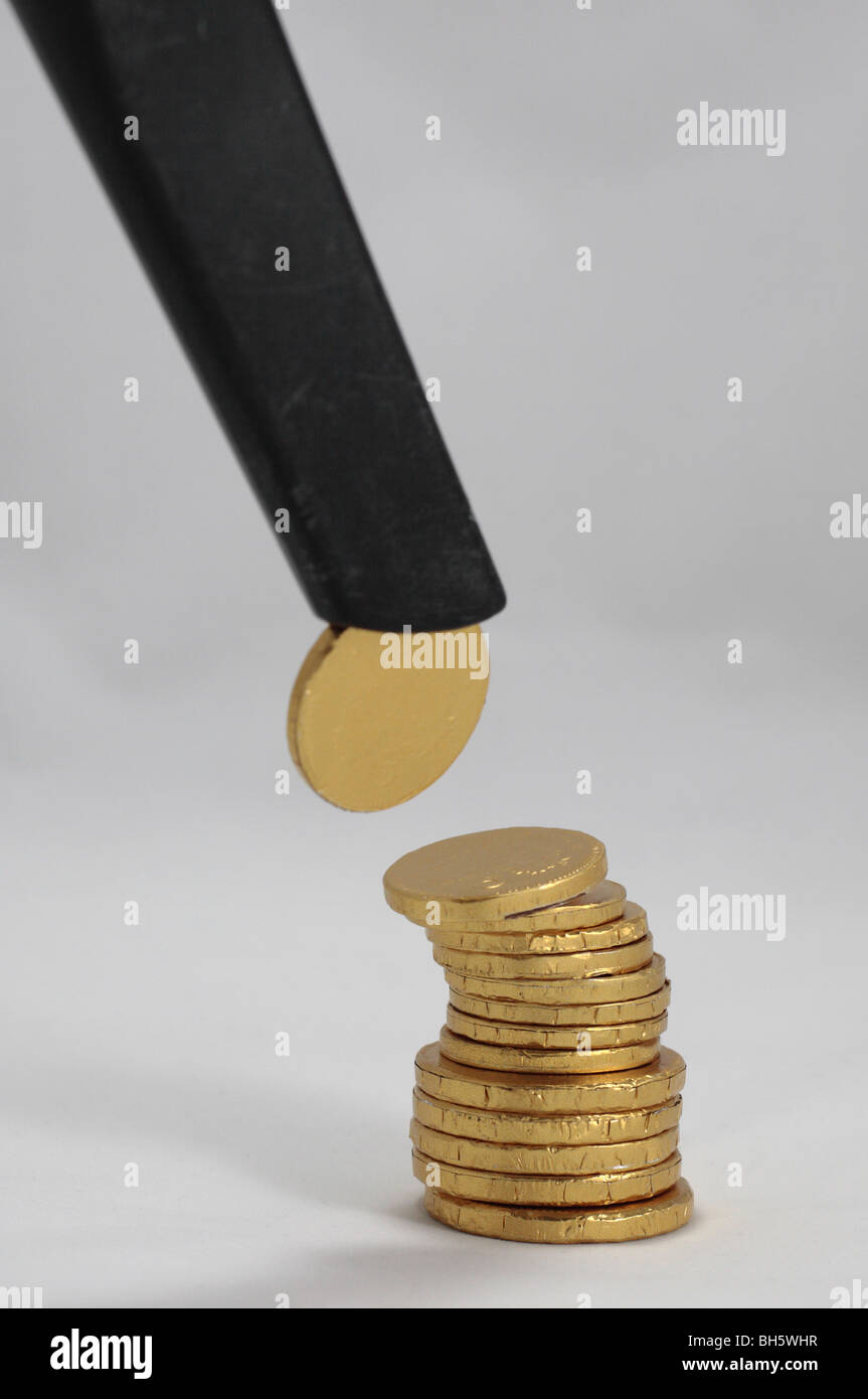 Ein Stapel von Schokoladen-Münzen mit einem "gesaugt" aus der oberen symbolisiert Abschreibungen, Rezession, Geld usw. verschwinden. Stockfoto
