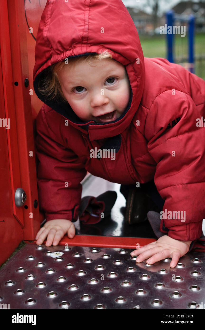 Kleines Kind auf einer Folie auf einem Spielplatz spielen Stockfoto