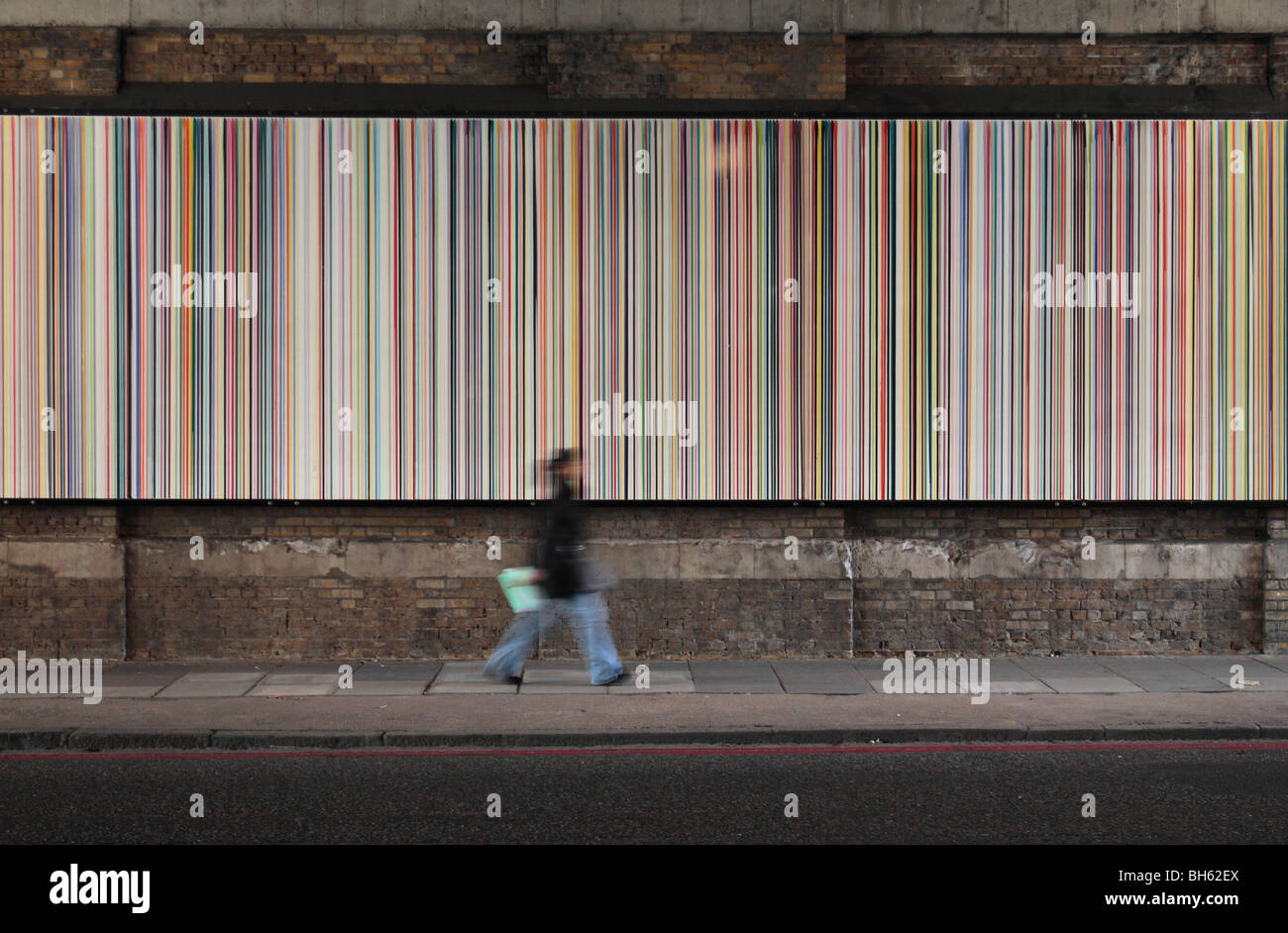 Eine Person Vorbeigehen "Gießen Linien: Southwark Street" Artwork von Ian Davenport unter einer Eisenbahnbrücke, London, UK. Stockfoto