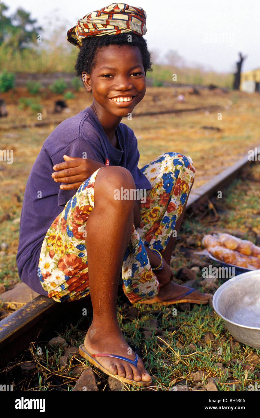 KIND SITZT AUF EINEM TRACK ZU VERKAUFEN ESSEN IN DER NÄHE DER STATION AN DER GRENZE ZWISCHEN DER ELFENBEINKÜSTE UND BURKINA FASO Stockfoto