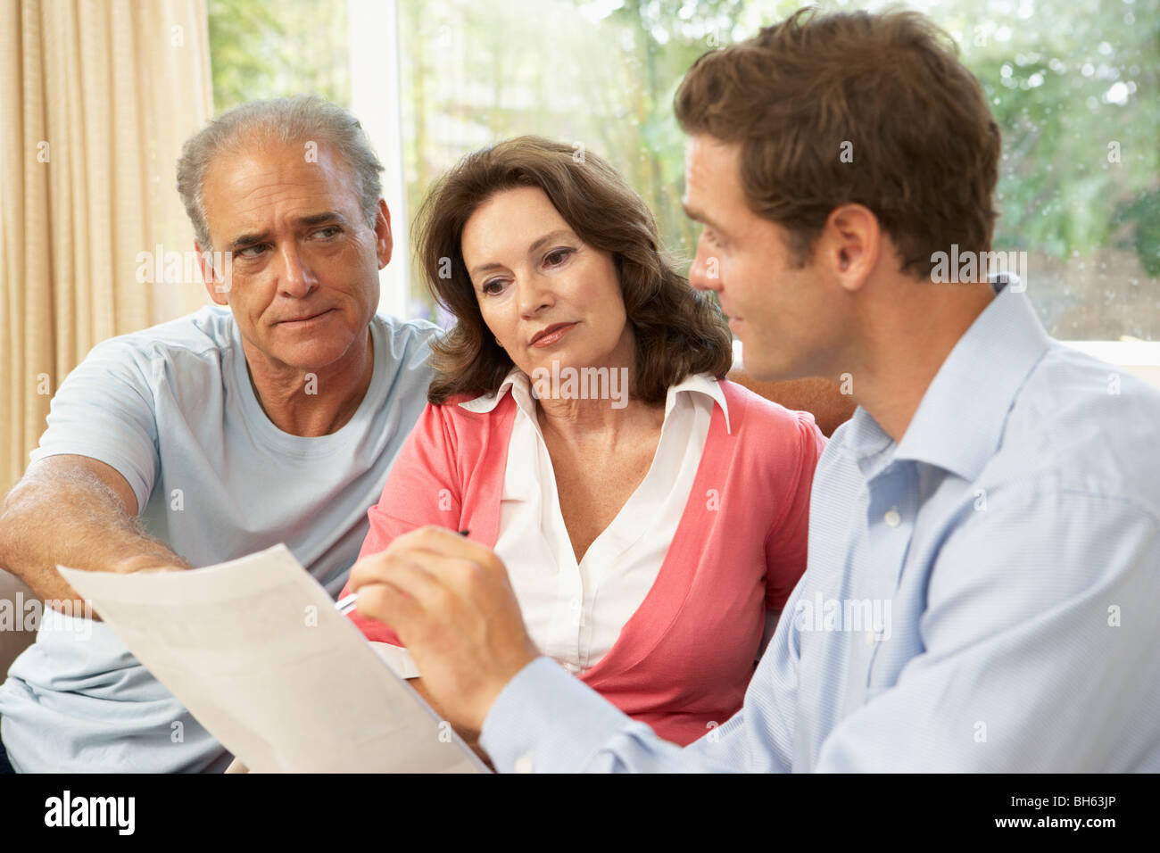 Älteres Paar mit Finanzberater zu Hause Stockfoto