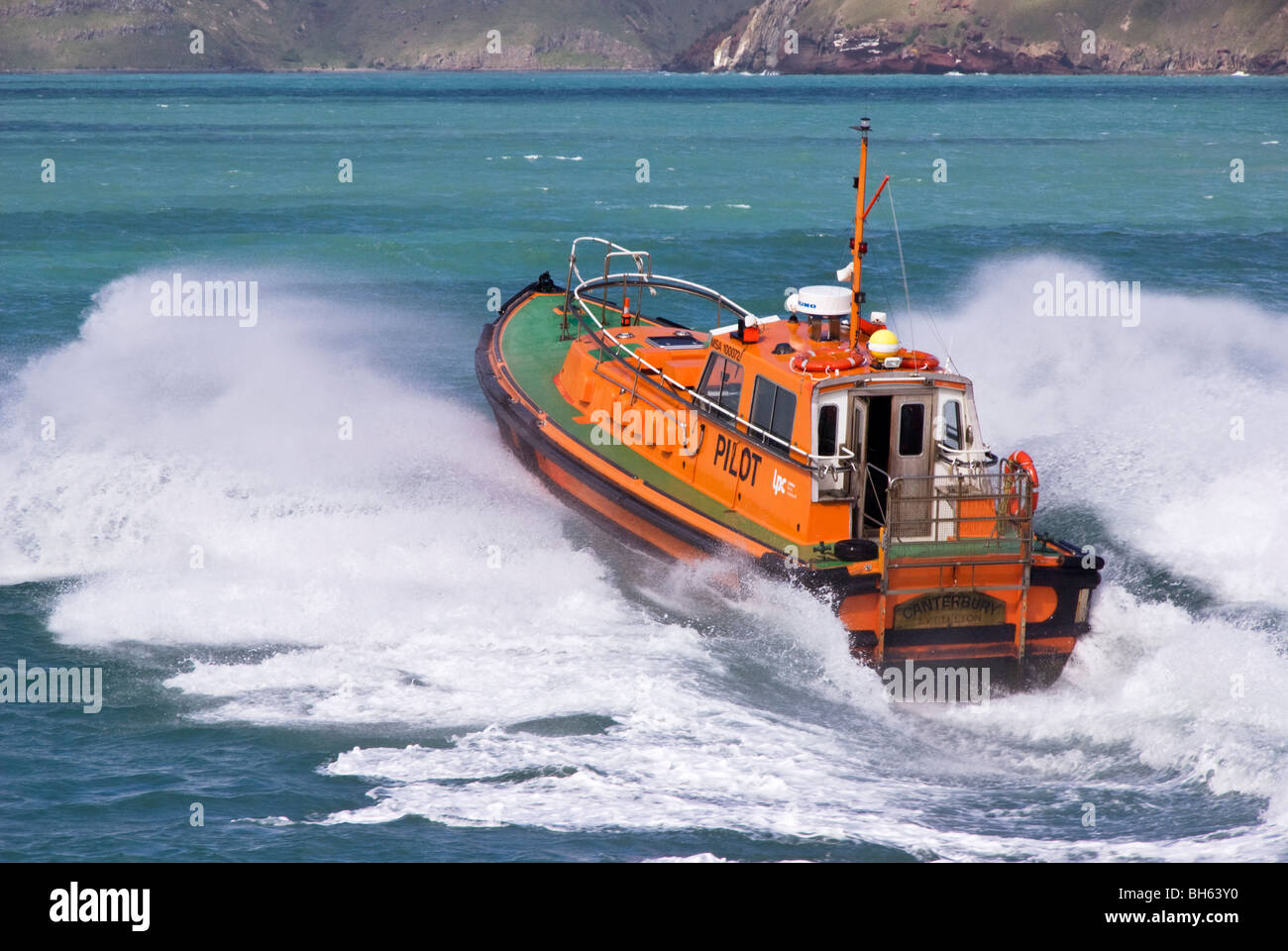 Ein Hafen Lotsenboot Köpfe mit Geschwindigkeit ein ankommendes Schiffes an der Hafeneinfahrt zu erfüllen. Stockfoto