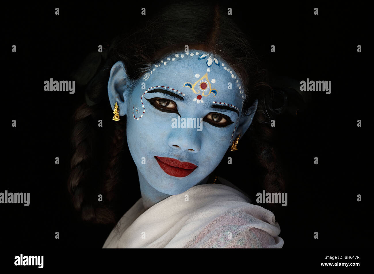 Indisches Mädchen Gesicht malen als die hinduistische Göttin Sita vor einem schwarzen Hintergrund. Indien Stockfoto