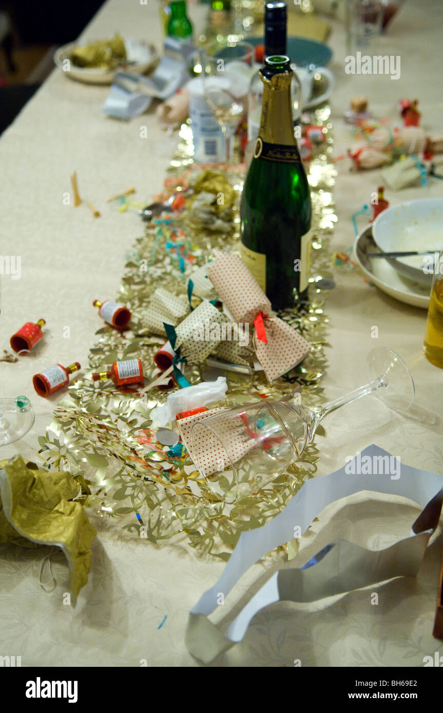 Gebrauchte Christmas Cracker und leere Flasche Champagner nach einer Weihnachtsfeier. Stockfoto