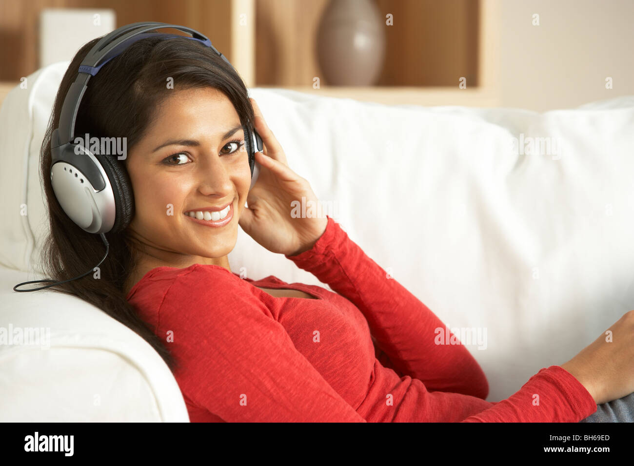 Junge Frau Musikhören zu Hause Stockfoto