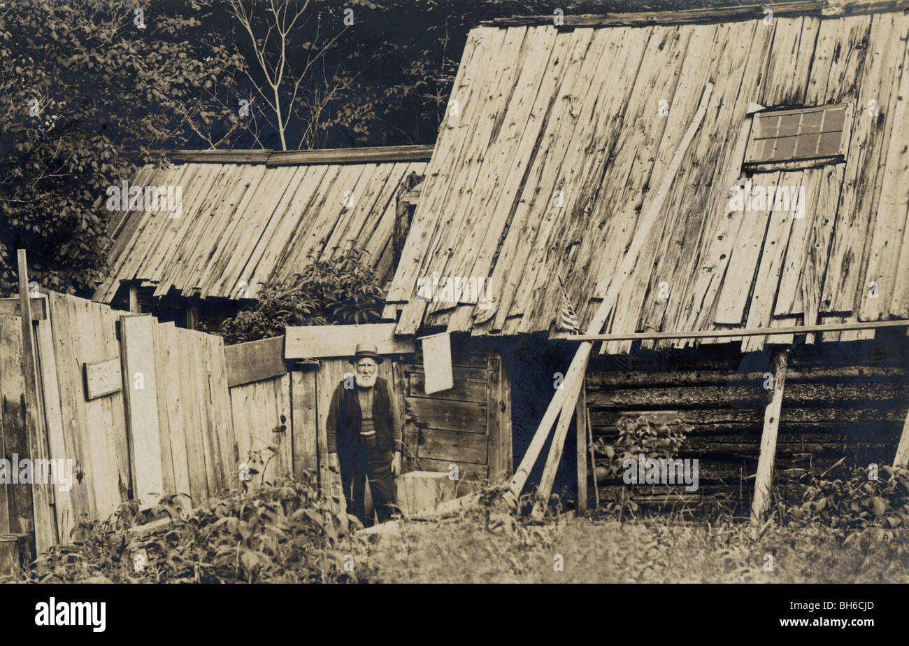 Alter Mann in baufälligen, ungleichmäßige unregelmäßige Blockhütte Stockfoto