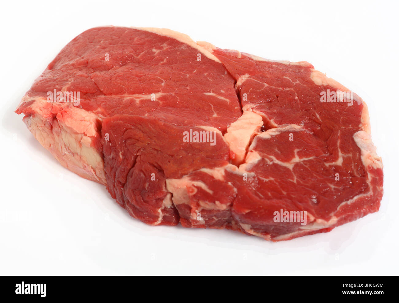 Ein Roh Ribeye Steak auf einem weißen Hintergrund mit einem sehr leichten Schatten Stockfoto