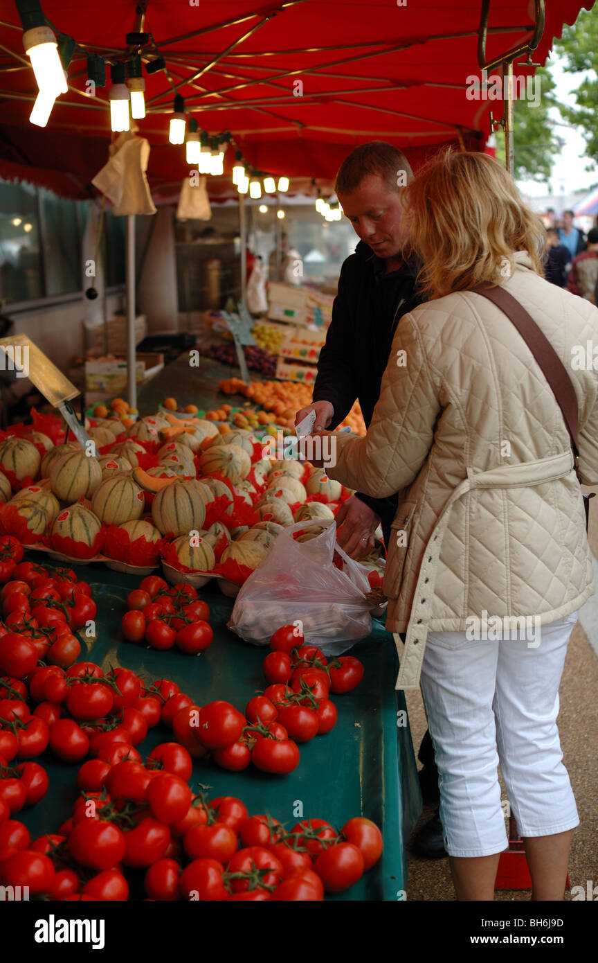 Ein männlicher Marktstand Inhaber Verkauf von Obst und Gemüse zu einer Frau Stockfoto