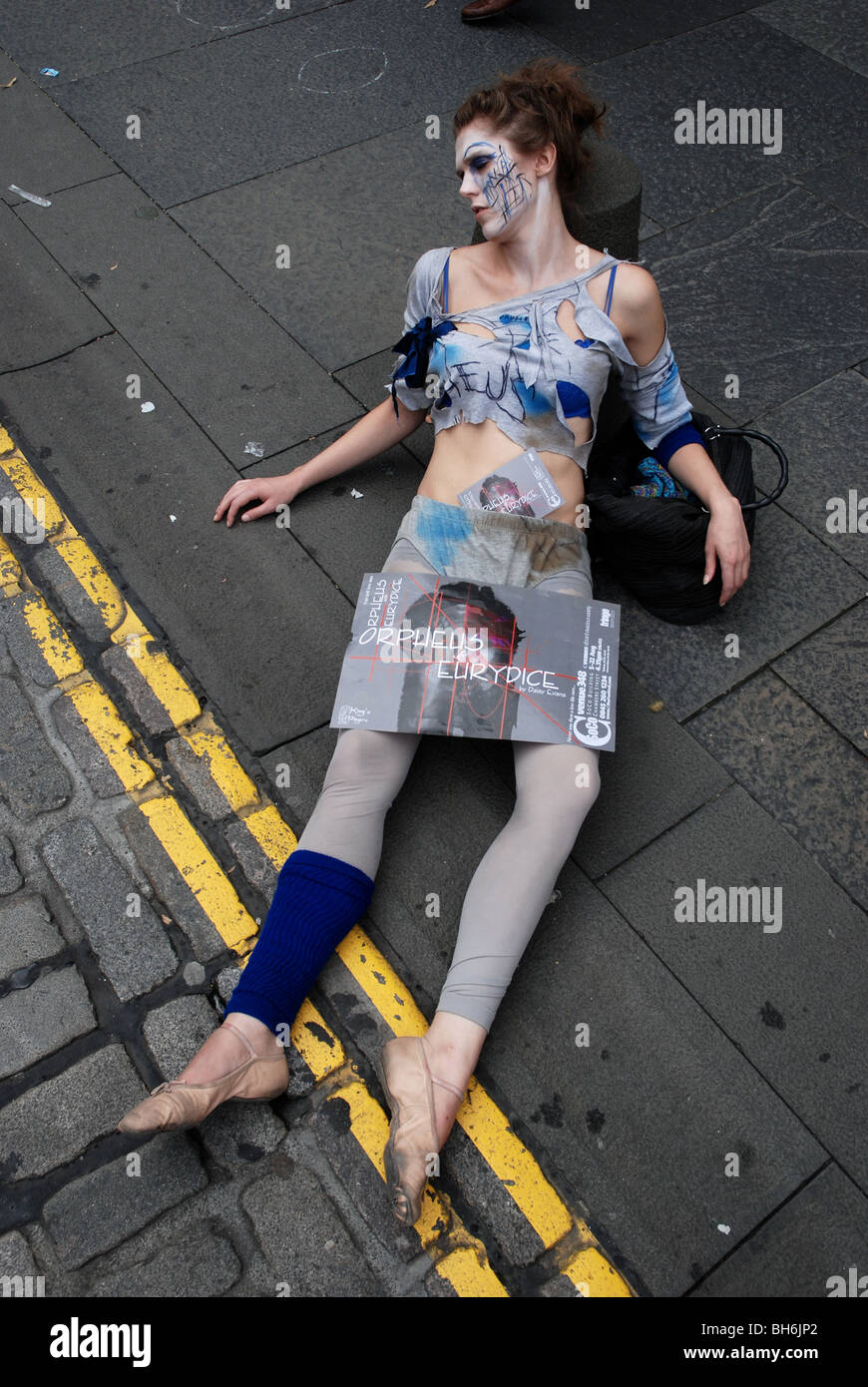 Mädchen auf dem Bürgersteig liegen, um eine Show auf dem Edinburgh Festival Fringe zu fördern Stockfoto