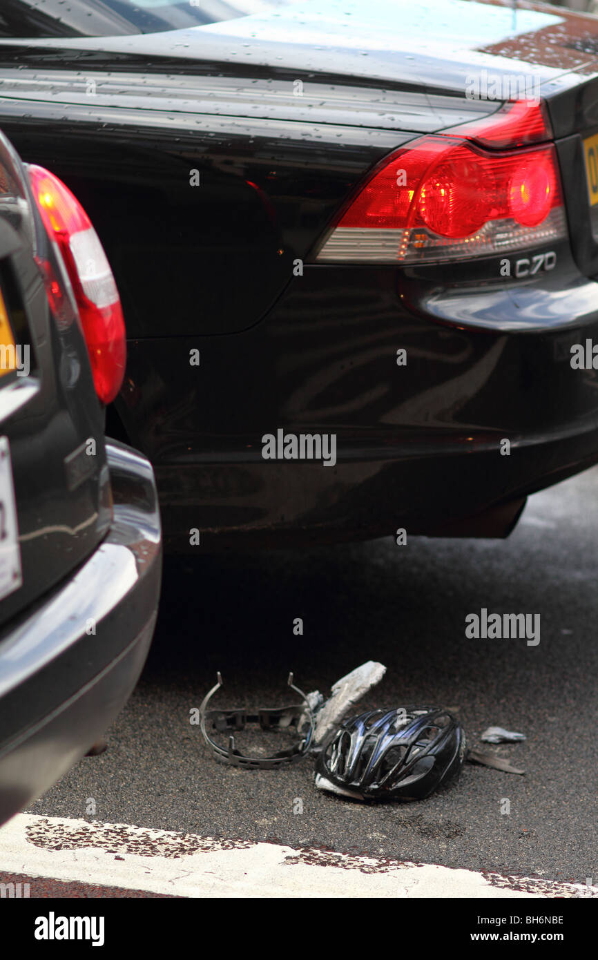 Ein Fahrradhelmes liegt zerkleinert und auf der Straße in der Nähe von Kings Cross, London, zerstört, als Autos vorbei fahren. Stockfoto