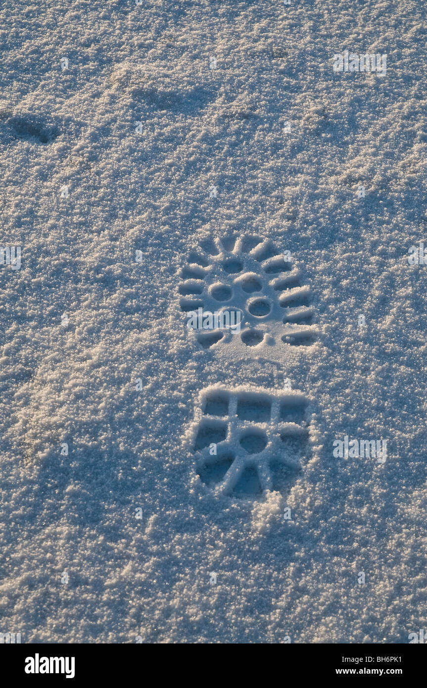 dh SCHNEE HINTERGRUND Walking Boot Fuß drucken in Schnee-Fußabdruck Mark Schuhstruktur Schritt Füße Drucke Stockfoto