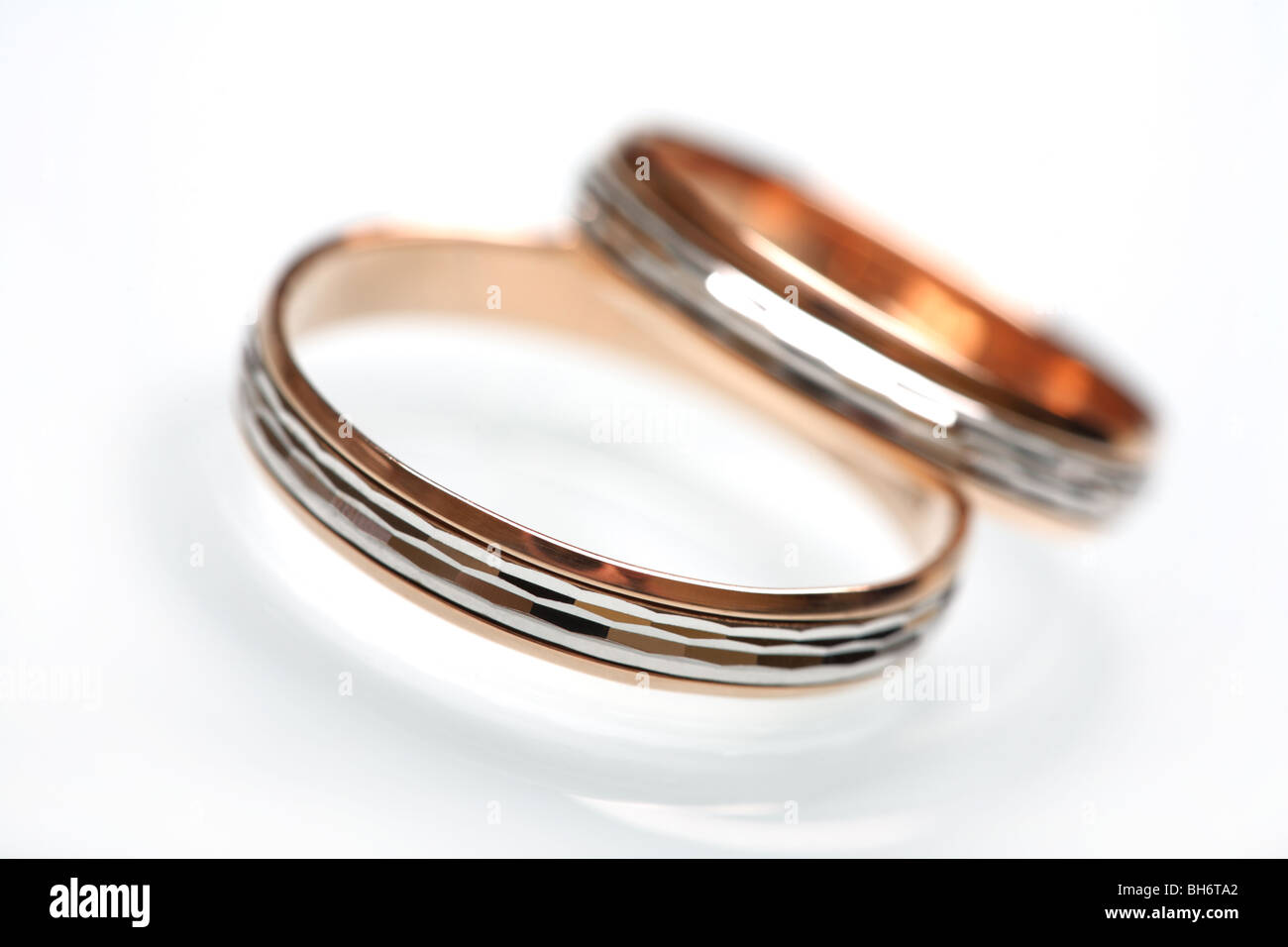 Trauringe gelb-und Weißgold mit Diamanten geschnitten auf Weißglas. Stockfoto