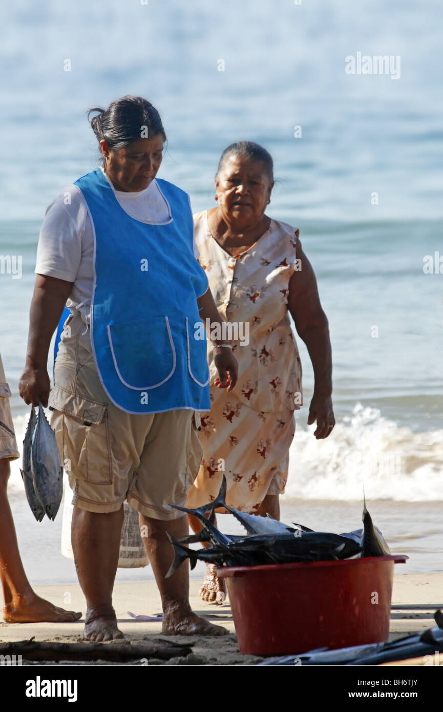 Einheimische Frauen tragen Fische am Strand von Puerto Escondido, Oaxaca, Mexiko Stockfoto