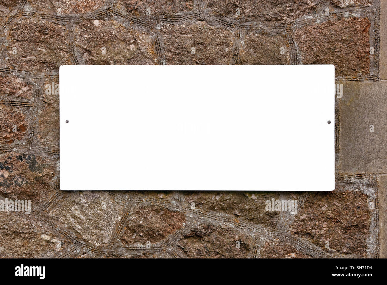 Weißes Schild auf einer alten Steinmauer leer ist, Ihre eigene Nachricht anzufügen. Stockfoto