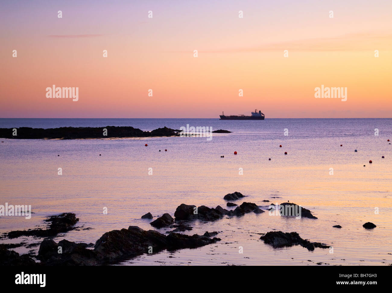 Sonnenaufgang in der Nähe von Garretstown, Co.Cork, Irland mit Schiff am Horizont Stockfoto