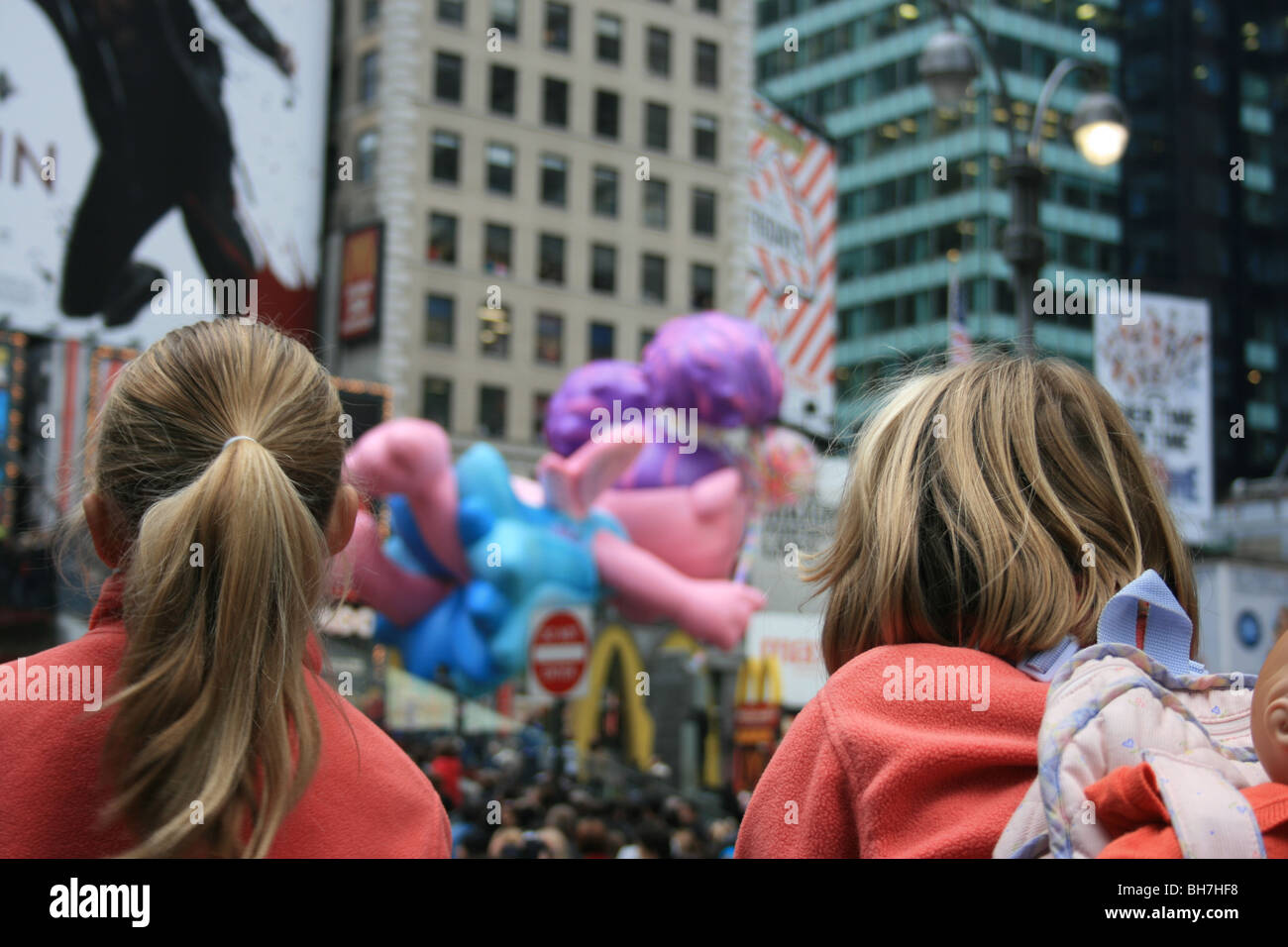 Zwei Mädchen beobachten die Macy's Thanksgiving Day Parade Pass über den Times Square. Stockfoto