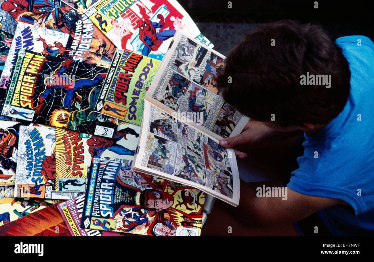 Junge mit Sammlung von Spiderman Comics Stockfoto